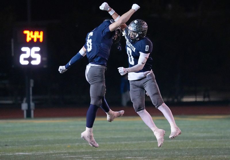Brighton’s Leo Hopkins (0) celebrates his interception of a Schroeder pass with teammate Patrick Rohr during their Section V Class A1 football sectional championship finals Friday, Nov. 7, 2025 at SUNY Brockport.