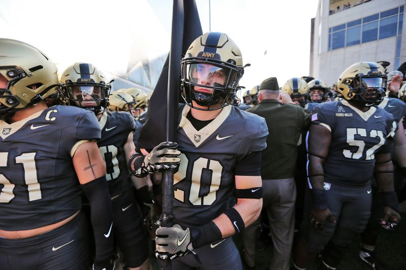 Nov 8, 2025; West Point, New York, USA; Army Black Knights safety Casey Larkin (20) holds a flag with his teammates before a game against the Temple Owls at Michie Stadium. Mandatory Credit: Danny Wild-Imagn Images