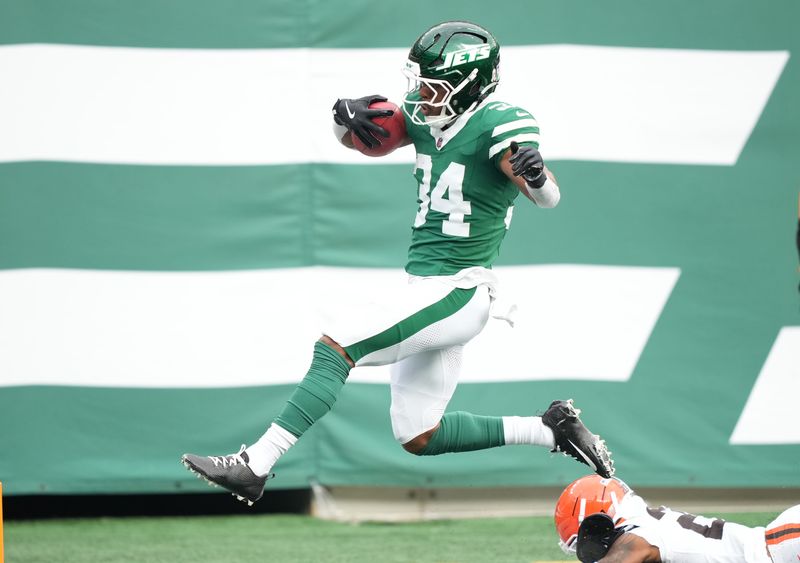 Nov 9, 2025; East Rutherford, New Jersey, USA; New York Jets running back Kene Nwangwu (34) scores a first quarter touchdown on a kickoff return against Cleveland Browns Cleveland Browns cornerback Tre Avery (28) and the Cleveland Browns at MetLife Stadium. Mandatory Credit: Robert Deutsch-Imagn Images
