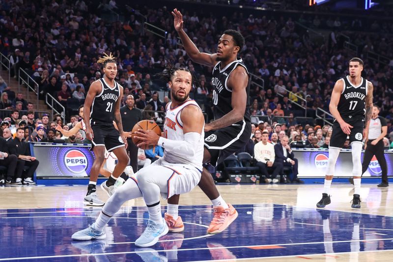 Nov 9, 2025; New York, New York, USA; New York Knicks guard Jalen Brunson (11) looks to spin away from Brooklyn Nets center Day'Ron Sharpe (20) in the first quarter at Madison Square Garden. Mandatory Credit: Wendell Cruz-Imagn Images
