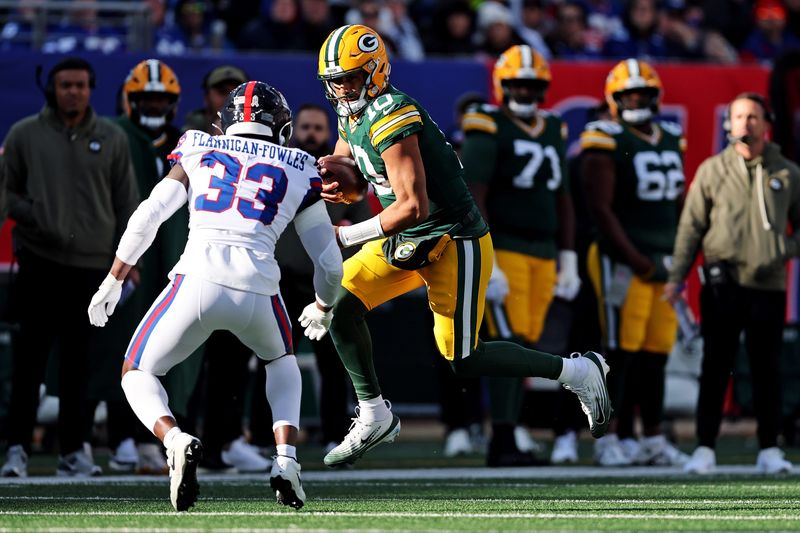 Nov 16, 2025; East Rutherford, New Jersey, USA; Green Bay Packers quarterback Jordan Love (10) runs the ball against New York Giants linebacker Demetrius Flannigan-Fowles (33) during the first quarter at MetLife Stadium. Mandatory Credit: Vincent Carchietta-Imagn Images