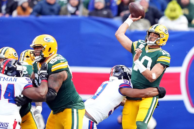Nov 16, 2025; East Rutherford, New Jersey, USA; Green Bay Packers quarterback Jordan Love (10) throws a pass under pressure from New York Giants linebacker Abdul Carter (51) during the second quarter at MetLife Stadium. Mandatory Credit: Robert Deutsch-Imagn Images