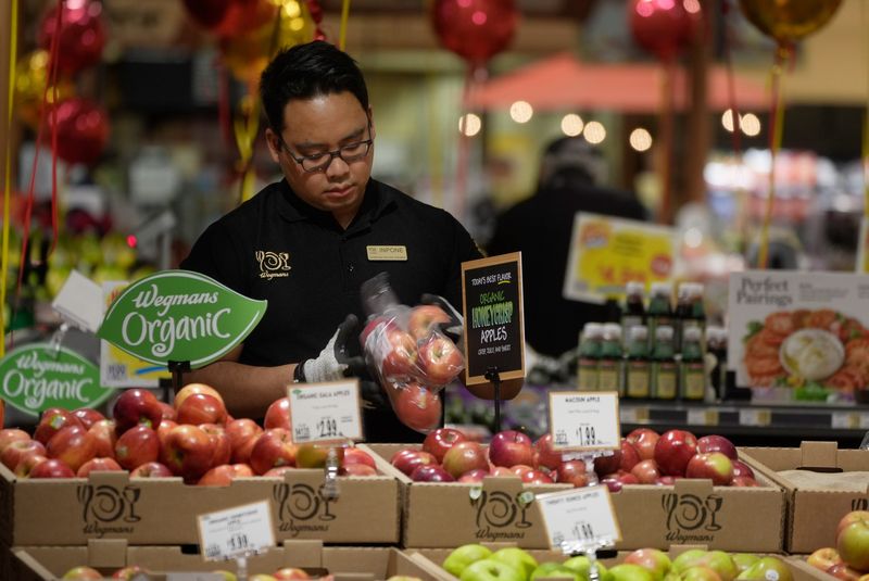Inpone Sonthana, produce coordinator at the Wegmans in Penfield, goes through the apple section looking for over-ripe or bruised produce to donate or, depending upon the condition, to be composted