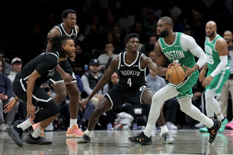 Nov 18, 2025; Brooklyn, New York, USA; Boston Celtics guard Jaylen Brown (7) looks to pass the ball against Brooklyn Nets forward Ziaire Williams (1) and center Day'Ron Sharpe (20) and guard Drake Powell (4) during the third quarter at Barclays Center. Mandatory Credit: Brad Penner-Imagn Images