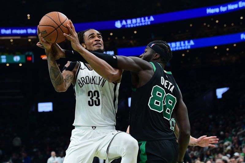 Nov 21, 2025; Boston, Massachusetts, USA; Boston Celtics center Neemias Queta (88) fouls Brooklyn Nets center Nic Claxton (33) during the first half at TD Garden. Mandatory Credit: Bob DeChiara-Imagn Images