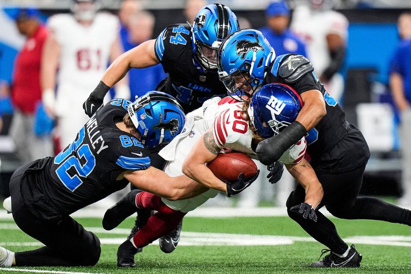 Detroit Lions tight end Ross Dwelley (82), linebacker Malcolm Rodriguez (44) and cornerback Khalil Dorsey (30) stop New York Giants punt returner Gunner Olszewski (80) during the first half at Ford Field in Detroit on Sunday, Nov. 23, 2025.