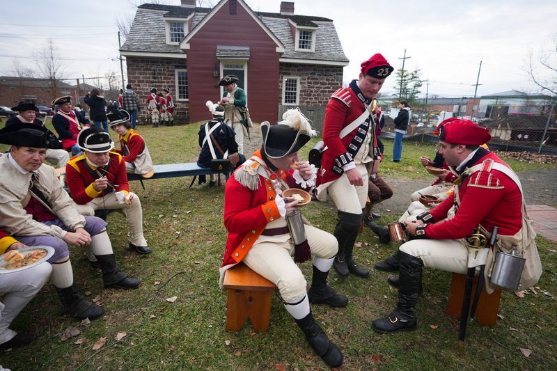 Revolutionary War reenactors eat lunch outside the Campbell-Christie House during a Revolutionary War reenactment at New Bridge Landing, Nov 23, 2025, River Edge, NJ, USA.