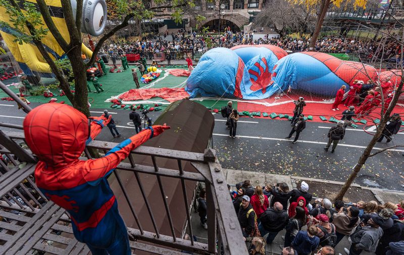 Arthur Colbert, 5, a real life Spiderman, watches from his fire escape as the Spiderman balloon is inflated during the annual balloon inflation for the Macy's Thanksgiving Day Parade in Manhattan Nov. 26, 2025.