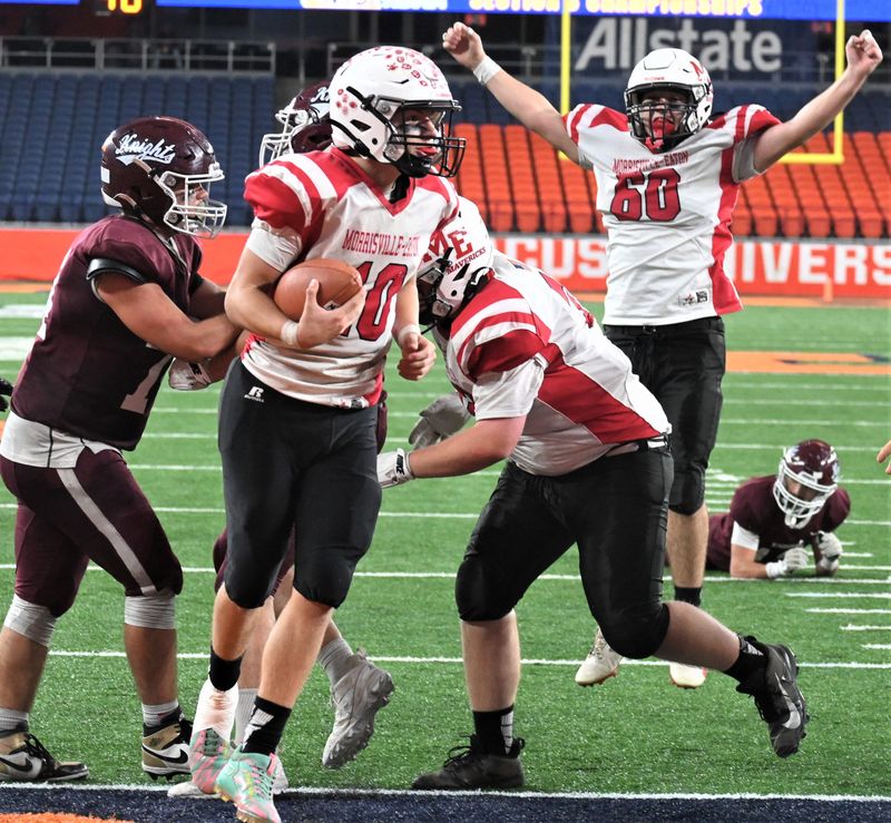 Morrisville-Eaton lineman Scott Rood raises his arms triumphantly as quarterback Landen Highers (left) scores the go-ahead touchdown late in the fourth quarter of Section III's November 14 eight-player football championship game in the JMA Wireless Dome. Morrisville-Eaton's state regional championship game is one of three state playoff contests at Cicero-North Syracuse High School that have been rescheduled from Friday of Thanksgiving weekend to Sunday by the New York State Public High School Athletic Association because of heavy snow in the forecast.