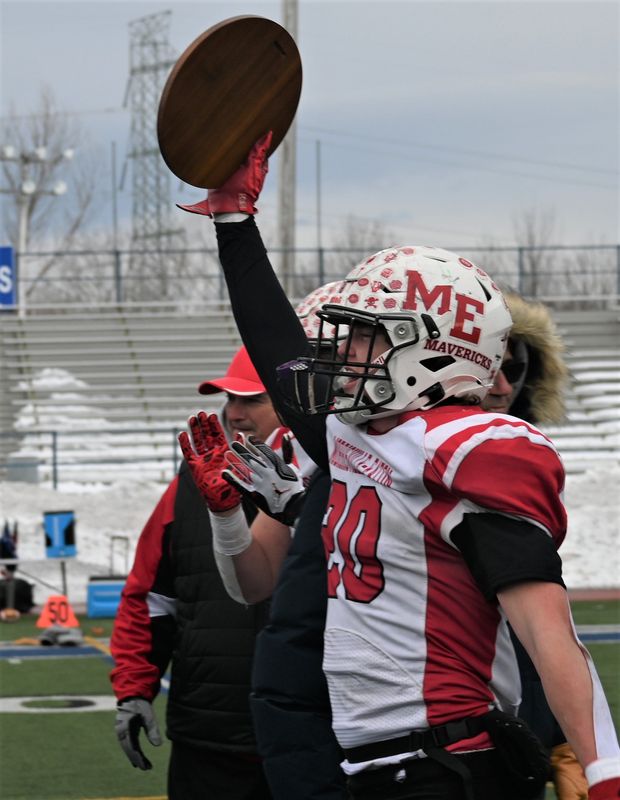 Morrisville-Eaton Maverick Mason Marland raises the championship plaque to his Maverick teammates after winning New York's state regional eight-player football title at Cicero-North Syracuse High School's Michael J. Bragman Athletic Complex Sunday.