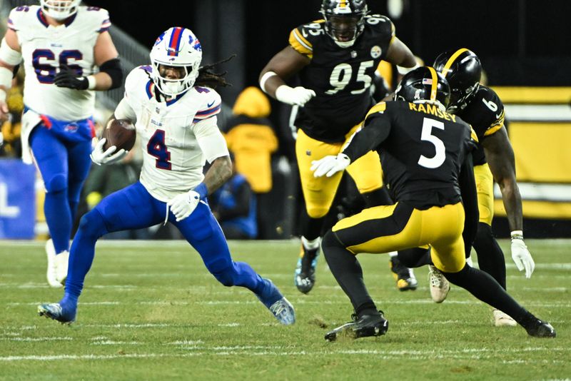 Nov 30, 2025; Pittsburgh, Pennsylvania, USA; Buffalo Bills running back James Cook III (4) rushes as Pittsburgh Steelers cornerback Jalen Ramsey (5) defends during the second quarter at Acrisure Stadium. Mandatory Credit: Barry Reeger-Imagn Images