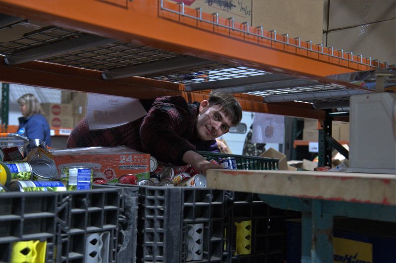 Nate Barr-Jobson, a volunteer at CHOW, helped sort through donations at the warehouse located in Binghamton on Dec. 1, 2025.
