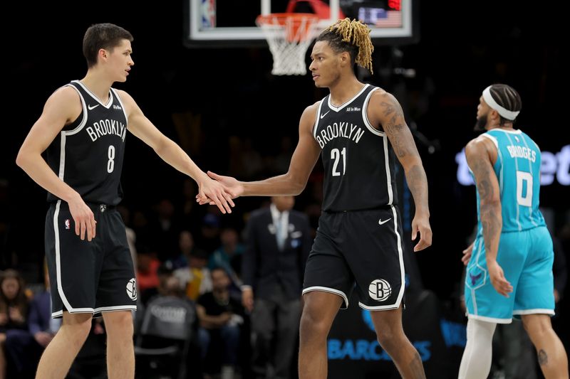 Dec 1, 2025; Brooklyn, New York, USA; Brooklyn Nets guard Egor Demin (8) high fives forward Noah Clowney (21) in front of Charlotte Hornets forward Miles Bridges (0) during the third quarter at Barclays Center. Mandatory Credit: Brad Penner-Imagn Images