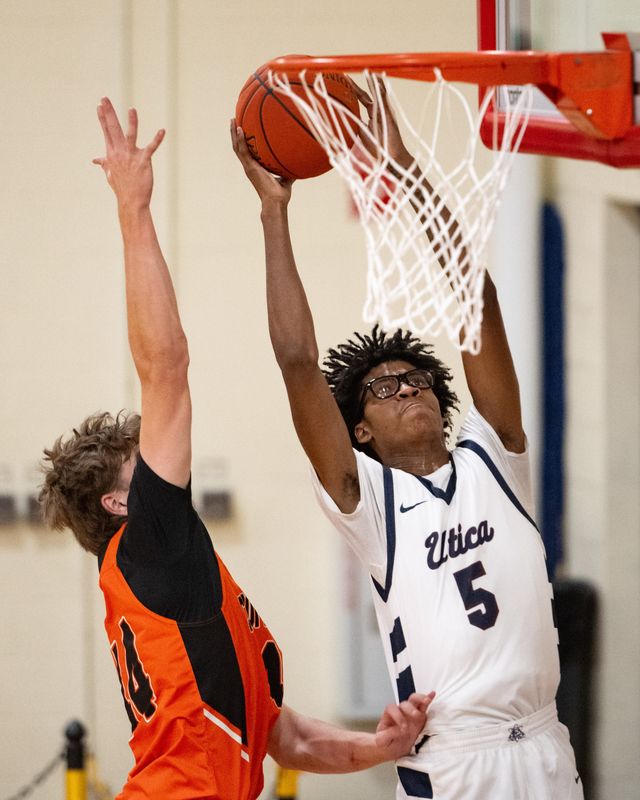 The Utica Academy of Science’s Jaylee Shaw Spann looks to dunk the ball while under pressure from Cooperstown’s Jackson Crisman Thursday.