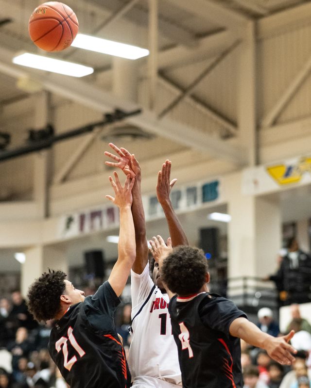 Proctor’s Rosear Devose shoots while under pressure from Rome Free Academy’s Christian Bevilacqua (21) and Surafia Norries (4) in Utica during a December 5 game. The Raiders and Black Knights split regular season decisions and will meet for a third time in the first round of Section III's 2026 Class AAA playoffs.