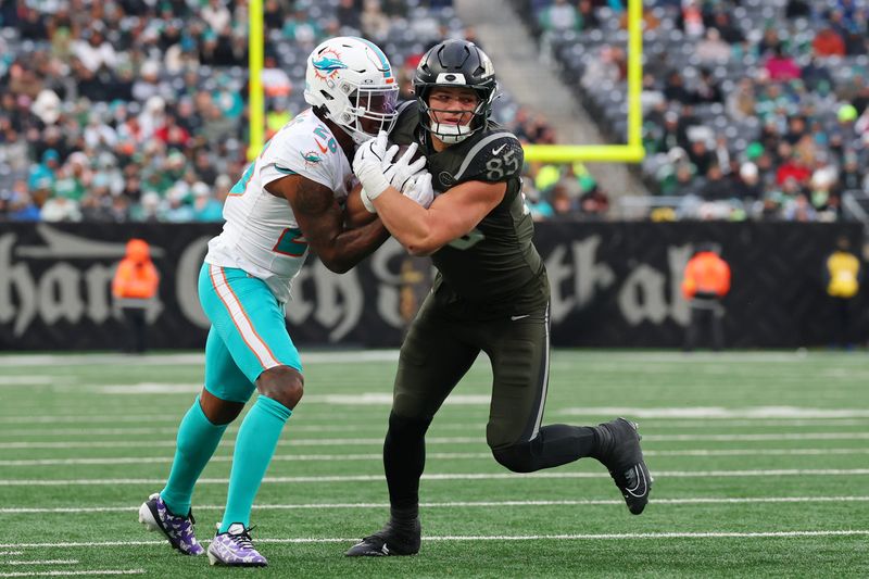 Dec 7, 2025; East Rutherford, New Jersey, USA; New York Jets tight end Mason Taylor (85) runs with the ball against Miami Dolphins cornerback Rasul Douglas (26) during the second half at MetLife Stadium. Mandatory Credit: Ed Mulholland-Imagn Images
