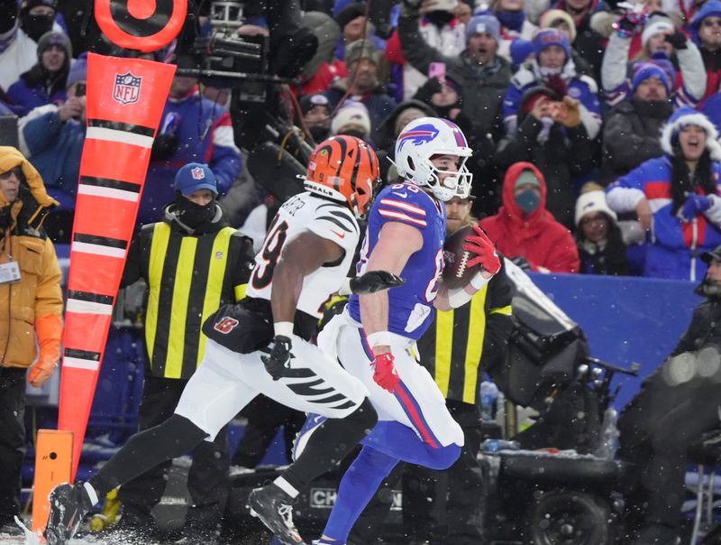 Buffalo Bills tight end Dawson Knox runs down the sidelines with Cincinnati Bengals linebacker Barrett Carter in pursuit during second half action.