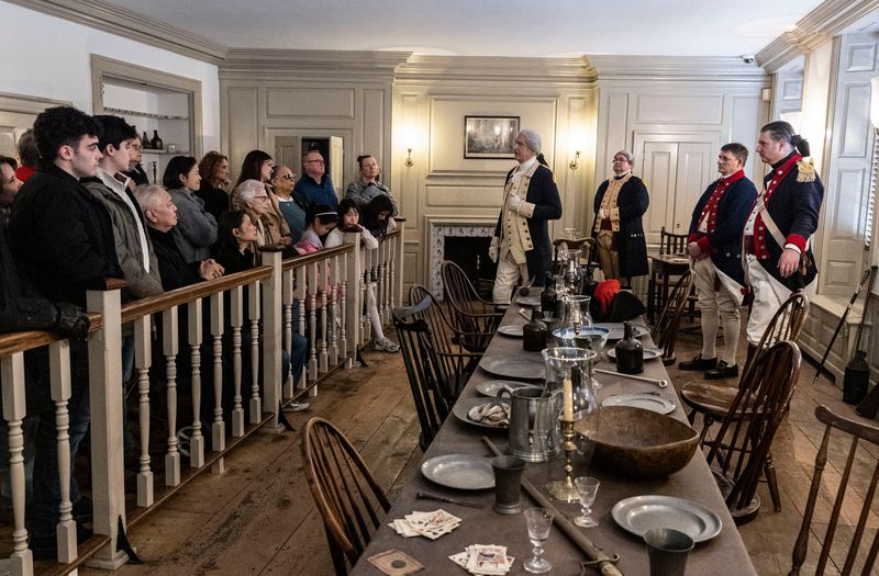 Revolutionary War reenactors Daniel Shippey, left, as General George Washington, Michael Funk as Major General Henry Knox, John Cornell as an unnamed officer, and Doug Thomas as Lt. Col. Benjamin Talmadge, chat with visitors after a reenactment of Gen. Washington's farewell to his officers at Fraunces Tavern in lower Manhattan at the end of the Revolutionary War Dec. 7, 2025. Washington bade his officers farewell in the Long Room at Fraunces Tavern on Dec. 4, 1783. The Long Room, where the reenactment takes place every year, is now part of the Fraunces Tavern Museum, one floor above the tavern. Fraunces Tavern is the oldest existing tavern in New York City.