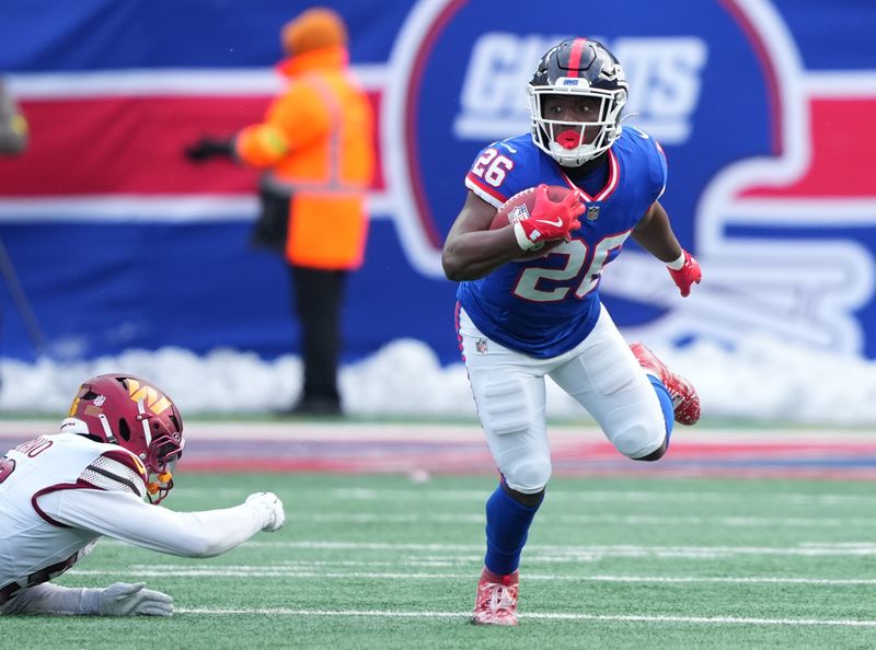 Dec 14, 2025; East Rutherford, New Jersey, USA; New York Giants running back Devin Singletary (26) runs with the ball against the Washington Commanders during the second quarter at MetLife Stadium. Mandatory Credit: Robert Deutsch-Imagn Images
