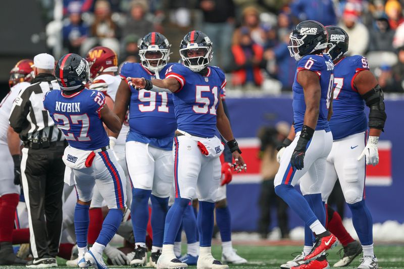 Dec 14, 2025; East Rutherford, New Jersey, USA; New York Giants linebacker Abdul Carter (51) and safety Tyler Nubin (27) celebrate a defensive stop during the first quarter against the Washington Commanders at MetLife Stadium. Mandatory Credit: Vincent Carchietta-Imagn Images
