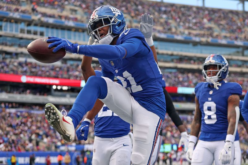 Dec 21, 2025; East Rutherford, New Jersey, USA; New York Giants cornerback Paulson Adebo (21) reacts after a turnover against the Minnesota Vikings during the first half at MetLife Stadium. Mandatory Credit: Vincent Carchietta-Imagn Images