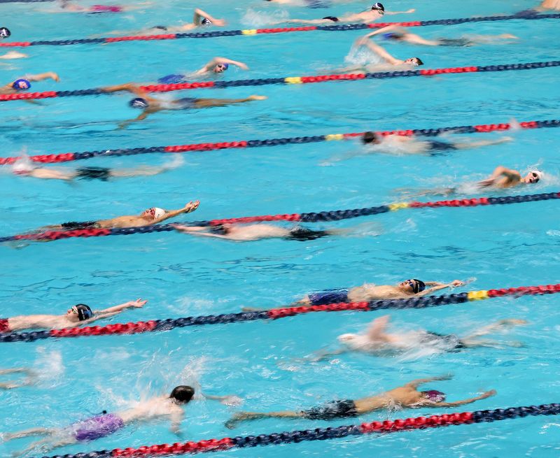 Swimmers warmup in the pool prior to the start of the 1A/2A State Swim prelims at the King County Aquatic Center in Federal Way, Wash. on Friday, Feb. 21, 2025.