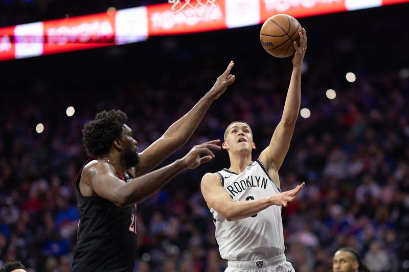 Dec 23, 2025; Philadelphia, Pennsylvania, USA; Brooklyn Nets guard Egor Demin (8) drives for a shot against Philadelphia 76ers center Joel Embiid (21) during the first quarter at Xfinity Mobile Arena. Mandatory Credit: Bill Streicher-Imagn Images