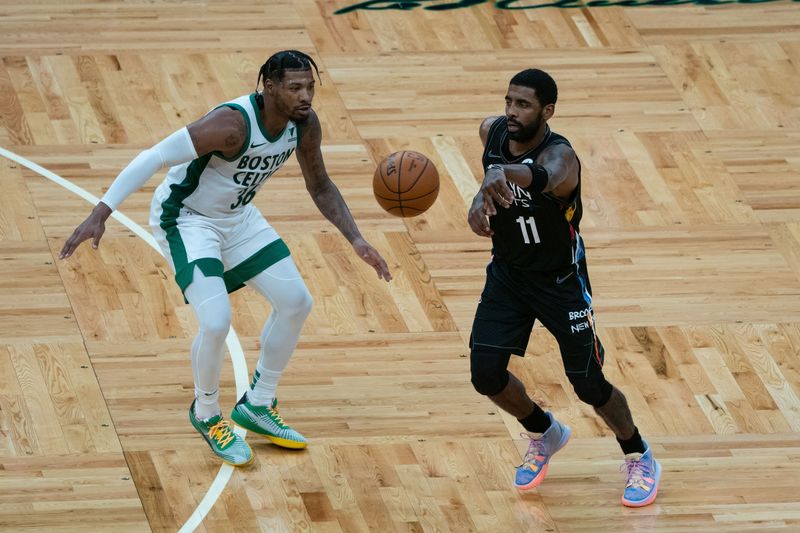 Dec 25, 2020; Boston, Massachusetts, USA; Brooklyn Nets point guard Kyrie Irving (11) passes the ball with Boston Celtics point guard Marcus Smart (36) defending during the third quarter at TD Garden. Mandatory Credit: Gregory Fisher-USA TODAY Sports
