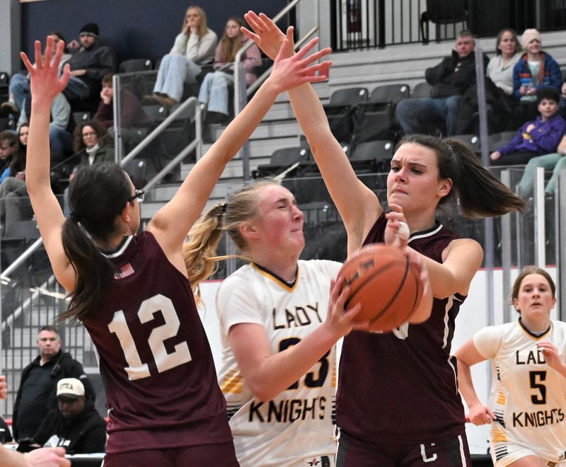 Holland Patent Golden Knight Riley Mierek drives between Clinton Comets Ella Brehaut (12) and Madison Rey during the secoind half Friday at the Nexus Center.