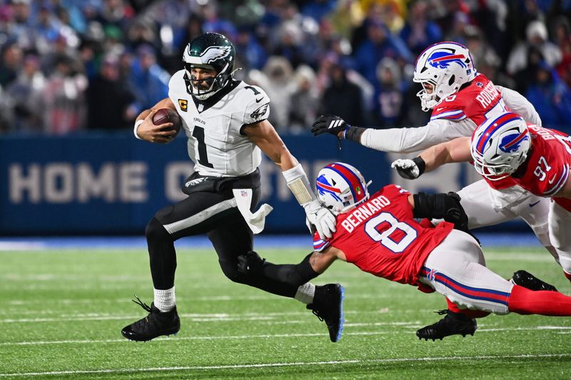 Philadelphia Eagles quarterback Jalen Hurts (1) runs the ball against Buffalo Bills linebacker Terrel Bernard (8), defensive end Greg Rousseau (50) and defensive end Joey Bosa (97) during the second quarter at Highmark Stadium.
