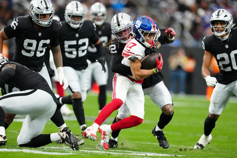 Dec 28, 2025; Paradise, Nevada, USA; New York Giants wide receiver Wan'Dale Robinson (17) is tackled by Las Vegas Raiders cornerback Eric Stokes (22) in the first quarter at Allegiant Stadium. Mandatory Credit: Stephen R. Sylvanie-Imagn Images