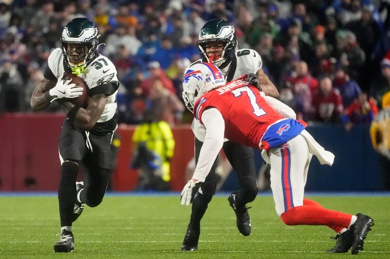 Dec 28, 2025; Orchard Park, New York, USA; Philadelphia Eagles running back Tank Bigsby (37) runs the ball and wide receiver DeVonta Smith (6) blocks against Buffalo Bills cornerback Taron Johnson (7) during the second quarter at Highmark Stadium. Mandatory Credit: Gregory Fisher-Imagn Images