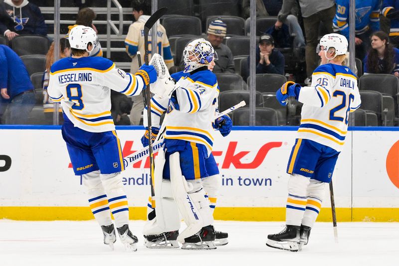 Buffalo Sabres goaltender Alex Lyon (34) celebrates with defenseman Michael Kesselring (8) and defenseman Rasmus Dahlin (26) after the Sabres defeated the St. Louis Blues at Enterprise Center.