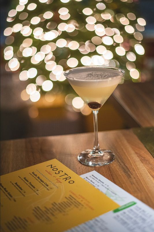 A signature cocktail at home with the Nostro Restobar + Lounge menu on a guest table in the elegant Italian eatery that indulged Utica foodies for 5 years before closing in Jan., 2026.