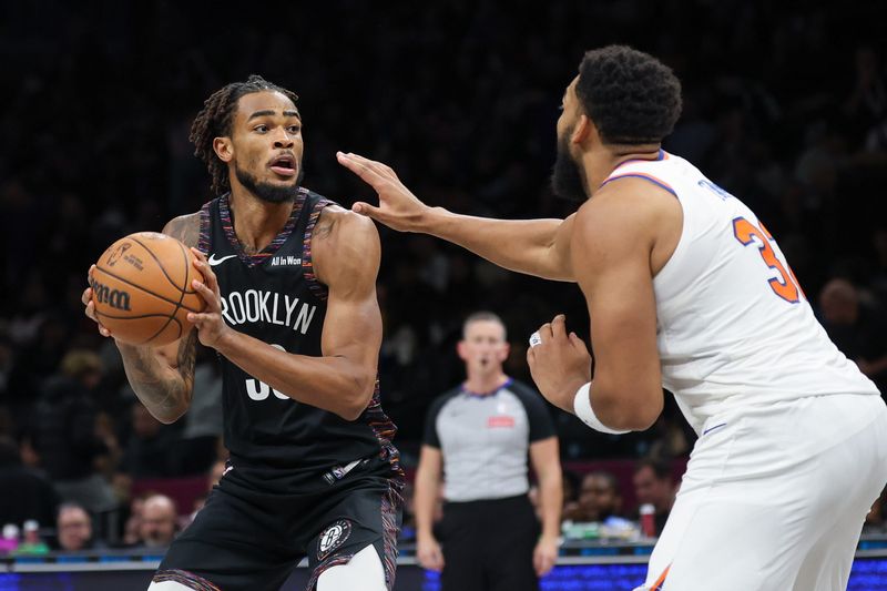 Nov 24, 2025; Brooklyn, New York, USA; Brooklyn Nets center Nic Claxton (33) is guarded by New York Knicks center Karl-Anthony Towns (32) during the second half at Barclays Center. Mandatory Credit: Vincent Carchietta-Imagn Images