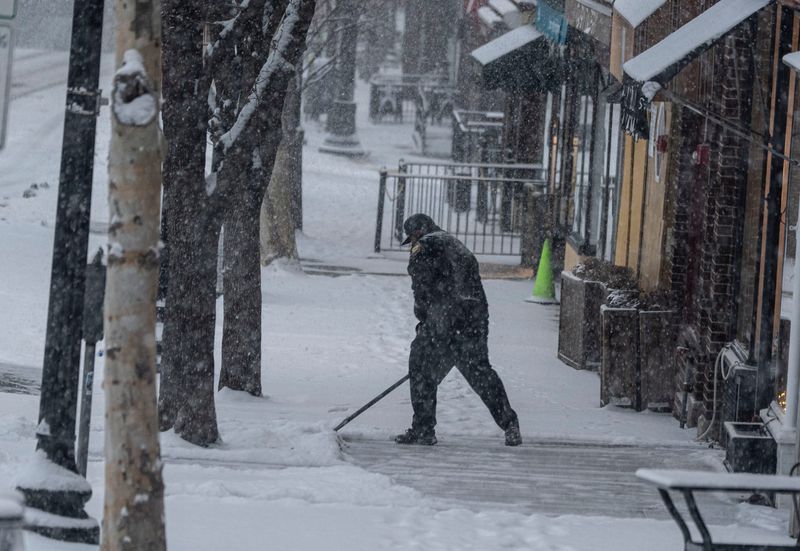 A merchant clears snow along Main Street in Tarrytown during the early hours of the winter storm Jan. 25, 2026. The storm was predicted to drop up to a foot of snow on the lower Hudson Valley.