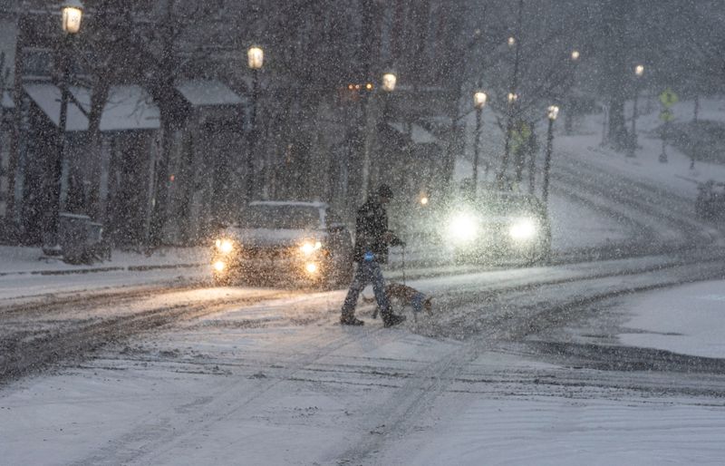 Rob Song crosses Route 9 in Tarrytown as he walk his dog Scotti during the early hours of the winter storm Jan. 25, 2026. The storm was predicted to drop up to a foot of snow on the lower Hudson Valley.