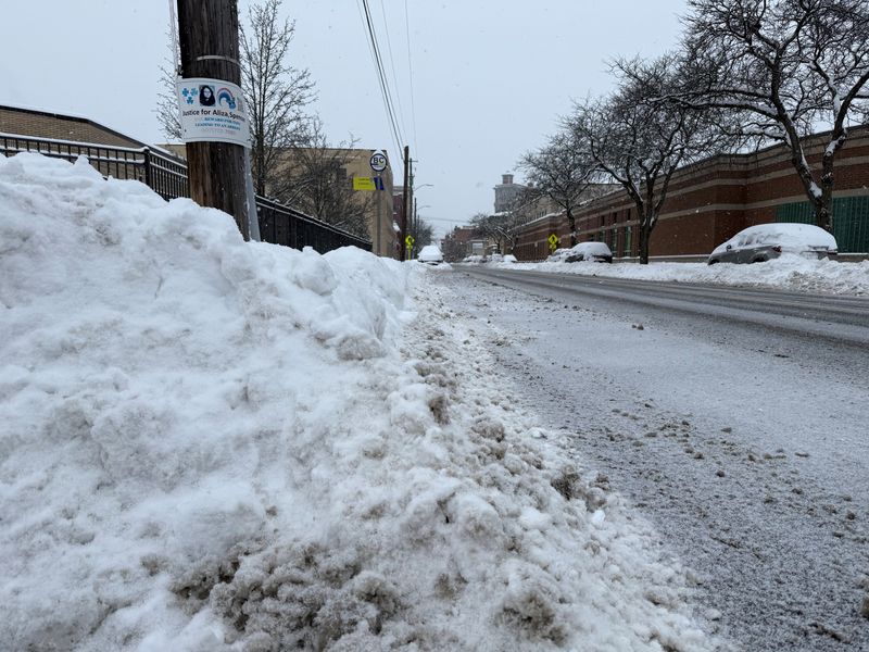 Sidewalks have knee high snow accumulation and parked cars are plowed in on various streets on Jan. 26, 2026.