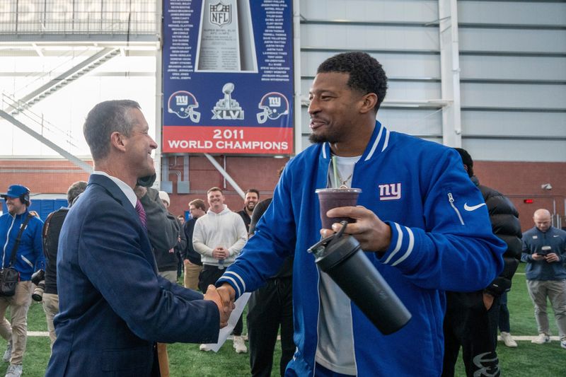 New Head Coach John Harbaugh shakes hands New York Giants quarterback Jameis Winston during a press conference introducing Harbaugh at the Quest Diagnostics Training Center in East Rutherford on Tuesday, Jan. 20, 2025.