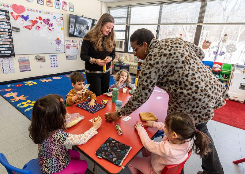 Tori Lennox and Deslyn Dyer, teachers at Childrenspace North, an early childhood education center in Croton, help their class of four-year olds during snack time Feb. 9, 2026. New York Governor Kathy Hochul has unveiled a plan to expand state funding for child care, which would include funding for universal pre-k.