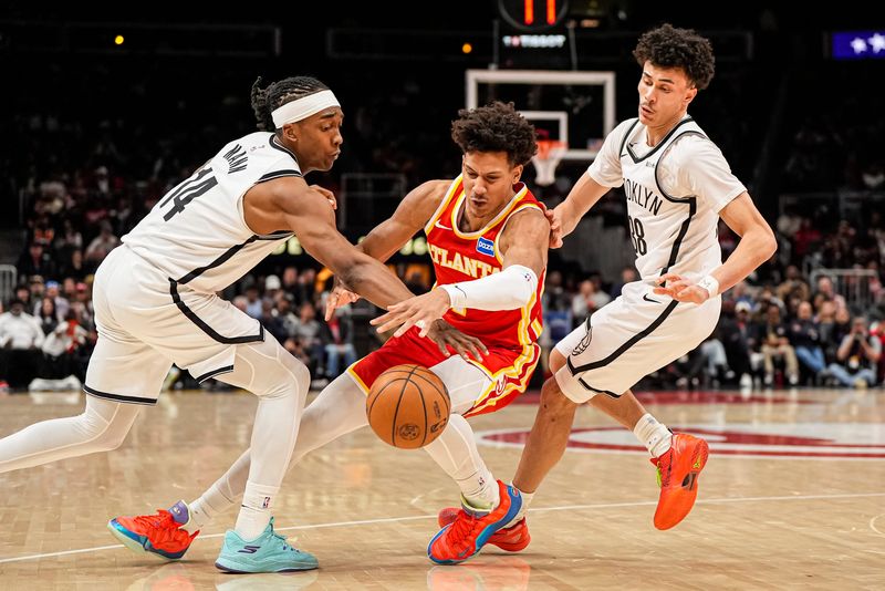 Feb 22, 2026; Atlanta, Georgia, USA; Atlanta Hawks forward Jalen Johnson (1) fights for the ball with Brooklyn Nets guard Terance Mann (14) and guard Nolan Traore (88) during the second half at State Farm Arena. Mandatory Credit: Dale Zanine-Imagn Images