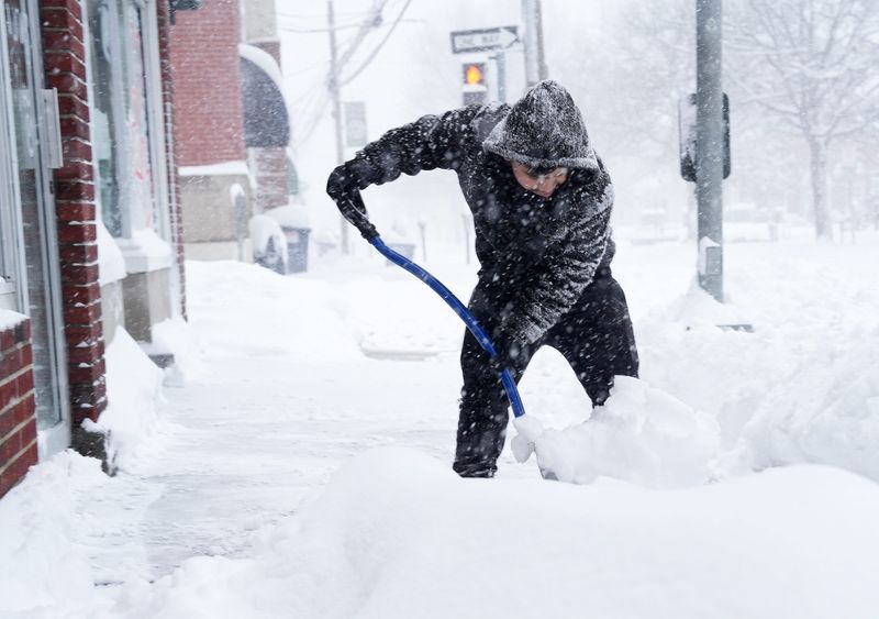 Moises shovels snow along Main Street in Brewster, New York Feb. 23, 2026.