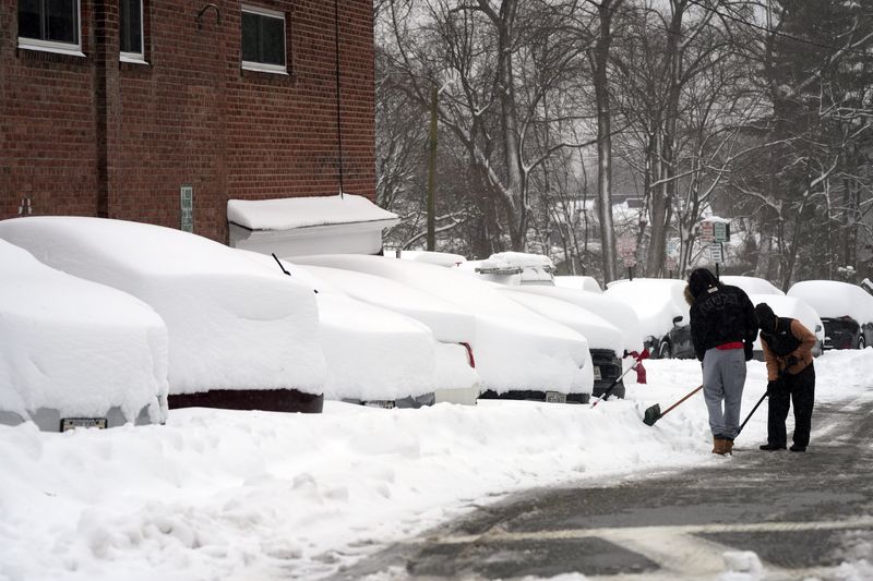 Shovelers begin to dig out as vehicles are covered in snow after a nor'easter hit the region Feb. 23, 2026 in Croton-on-Hudson.