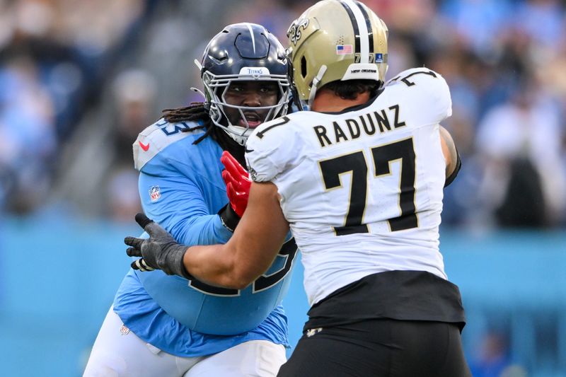 Dec 28, 2025; Nashville, Tennessee, USA; New Orleans Saints guard Dillon Radunz (77) blocks Tennessee Titans defensive tackle T'Vondre Sweat (93) during the second half at Nissan Stadium. Mandatory Credit: Steve Roberts-Imagn Images