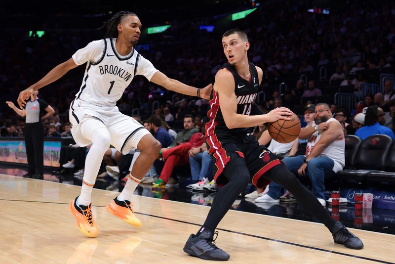Mar 3, 2026; Miami, Florida, USA; Miami Heat guard Tyler Herro (14) protects the basketball against Brooklyn Nets forward Ziaire Williams (1) during the third quarter at Kaseya Center. Mandatory Credit: Sam Navarro-Imagn Images