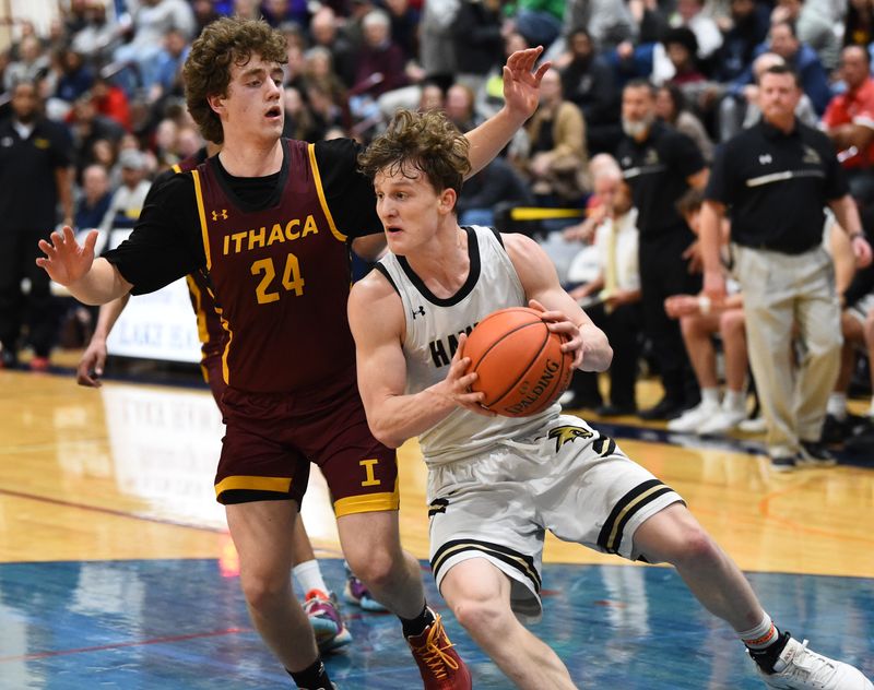 Corning's Nolyn Proudfoot drives to the hoop as Ithaca's Kole Charsky defends as the Hawks beat Ithaca, 90-68, in the Section 4 Class AAA boys basketball championship game March 6, 2026 at Watkins Glen High School.