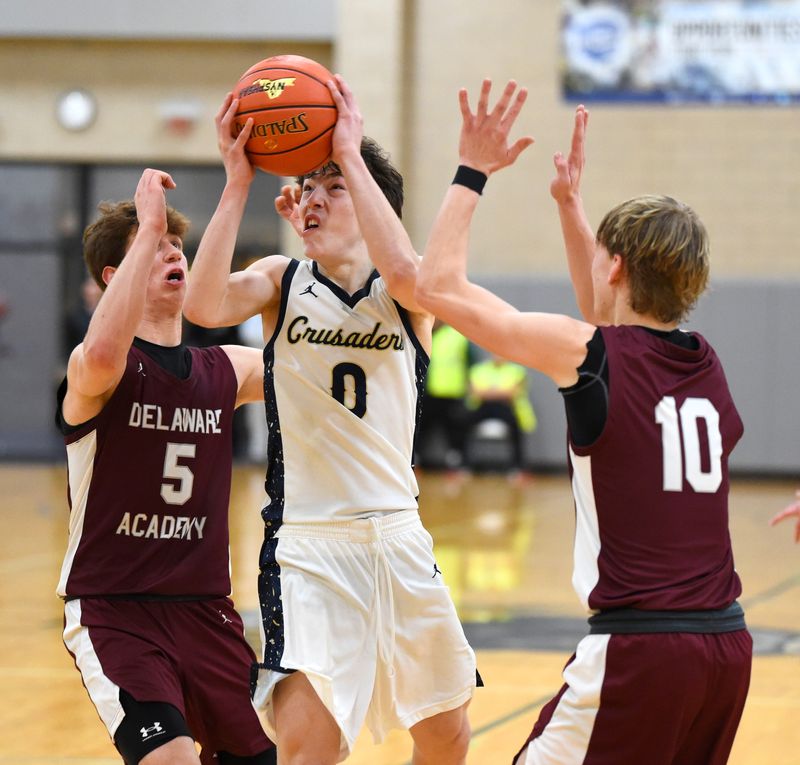 Elmira Notre Dame's Rocco Sayers (0) drives to the hoop as Delhi's Ben Schnabel (5) and John Wilson (10) defend during the Crusaders' 68-64 overtime win in the Section 4 Class C boys basketball championship game March 7, 2026 at Tompkins Cortland Community College in Dryden.