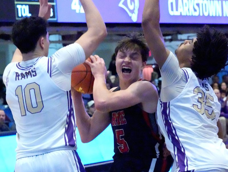 Rye's Henry Shoemaker drives between Clarkstown North's Jack Kavanagh,, left, and Rotimi Esiso during the Section 1 Class AA boys basketball championship game at the Westchester County Center Mar. 7, 2026.