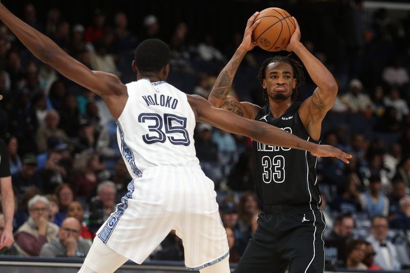 Jan 11, 2026; Memphis, Tennessee, USA; Brooklyn Nets center Nic Claxton (33) looks for an open teammate as Memphis Grizzlies center Christian Koloko (35) defends during the first quarter at FedExForum. Mandatory Credit: Petre Thomas-Imagn Images