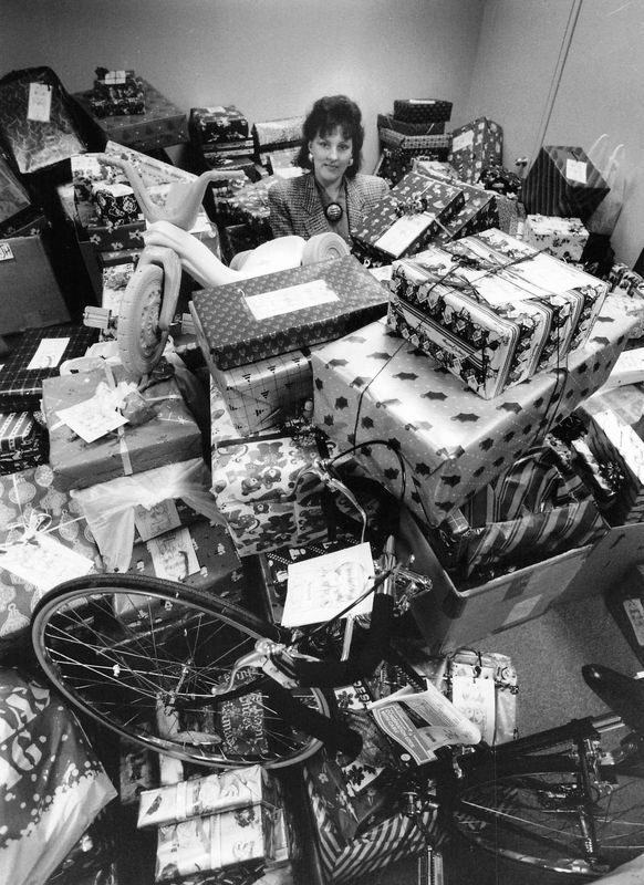 Nancy DeLancey sits in a storage room with gifts for Midtown Plaza’s Angel Tree program, circa 1985, in Rochester. The annual program collected donations for children and families during the holiday season.